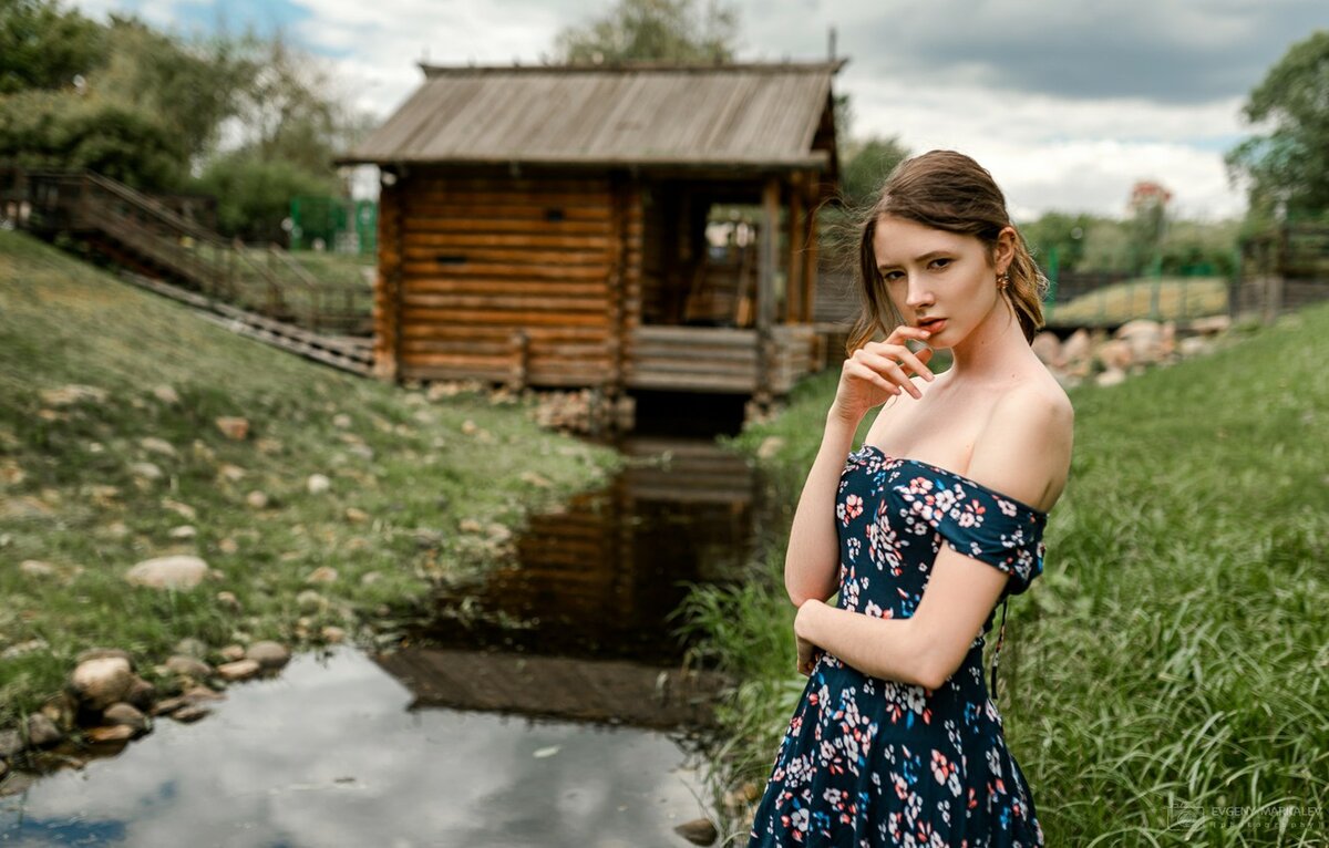 Деревенская девушка позирует на речке перед камерой