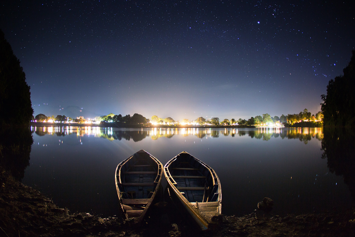 Побережье озера ночью с лодочками