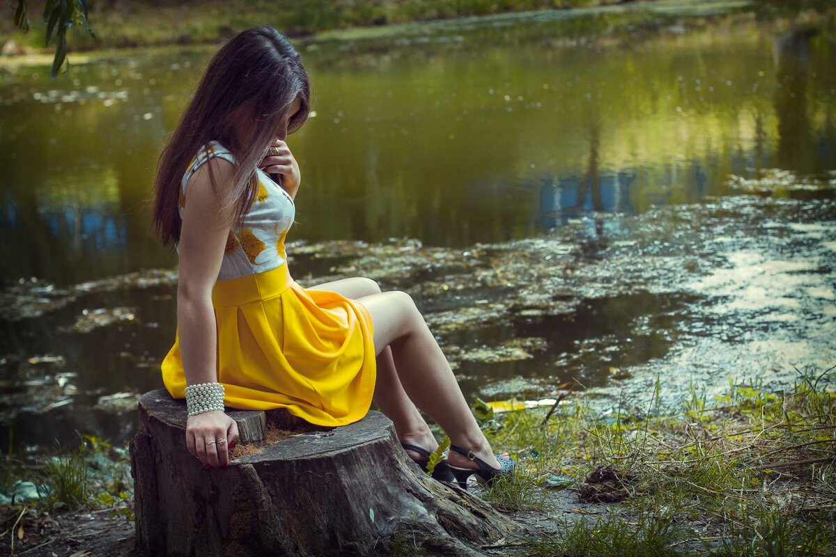 На берегу реки около дерева великолепная дама с хвостиками
