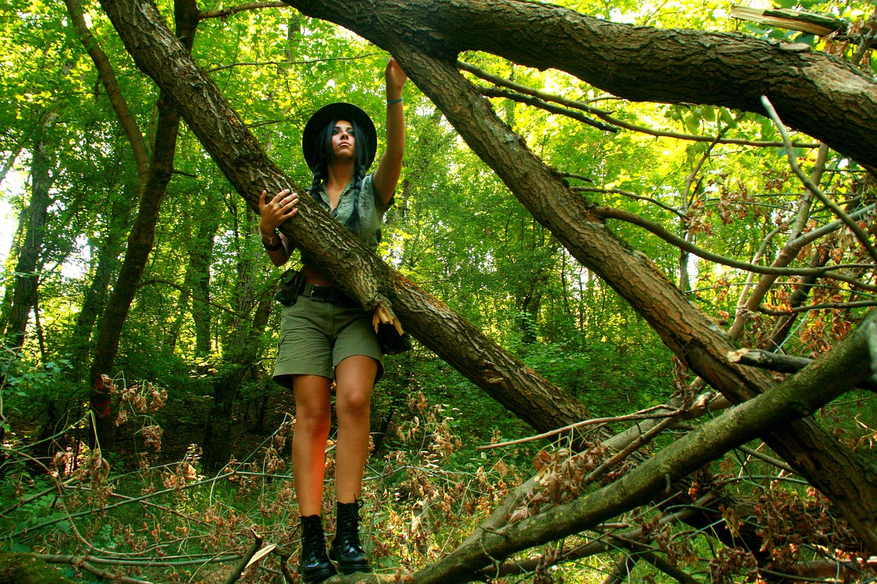 Брюнетка снимает шорты под деревом в лесу