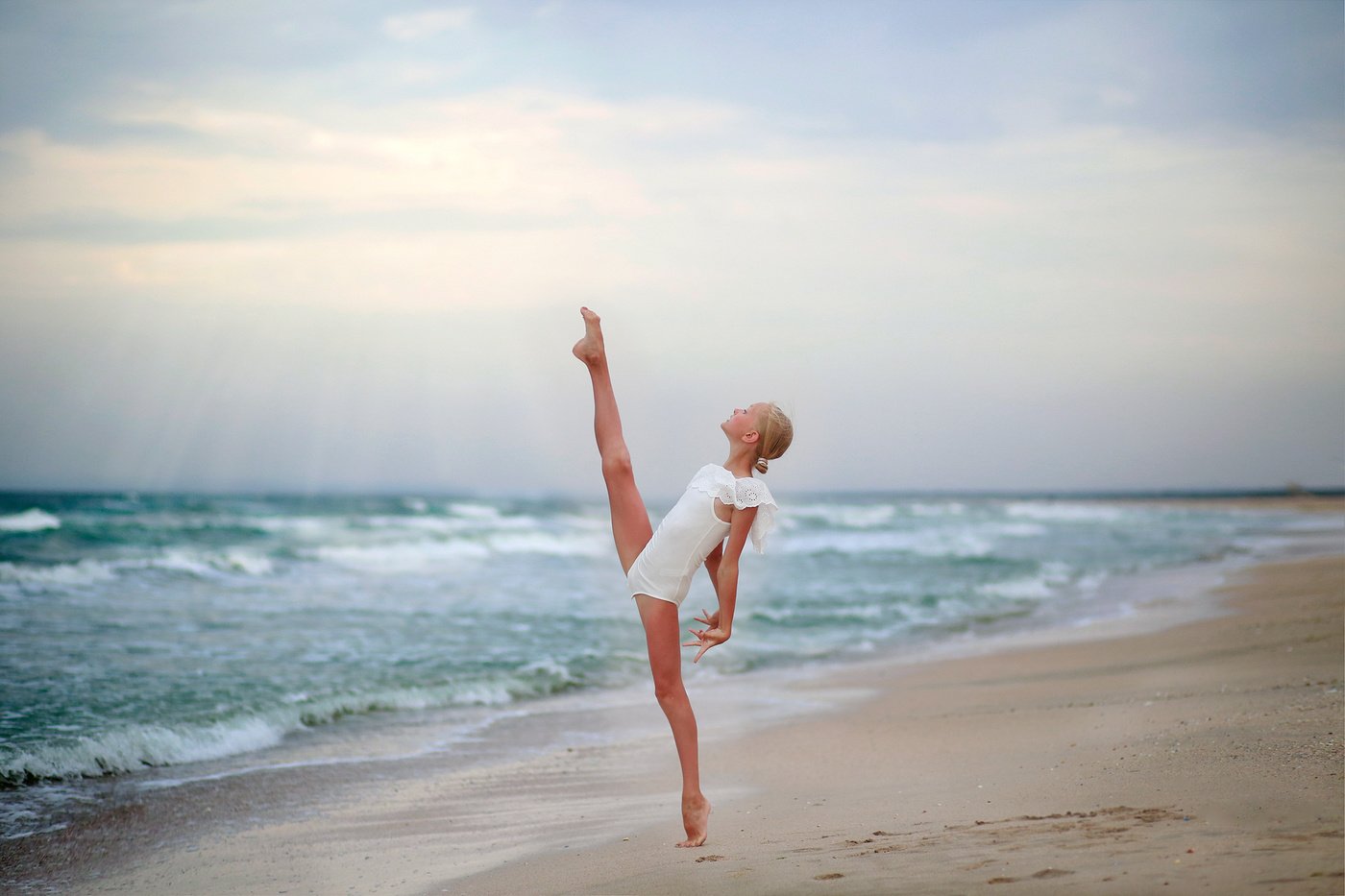 Миленькая танцовщица тренируется на пляже голышом