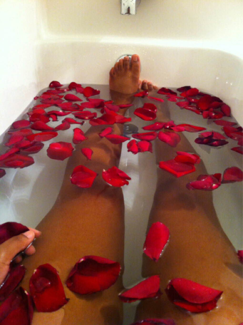 Ноги в ванной с лепестками роз