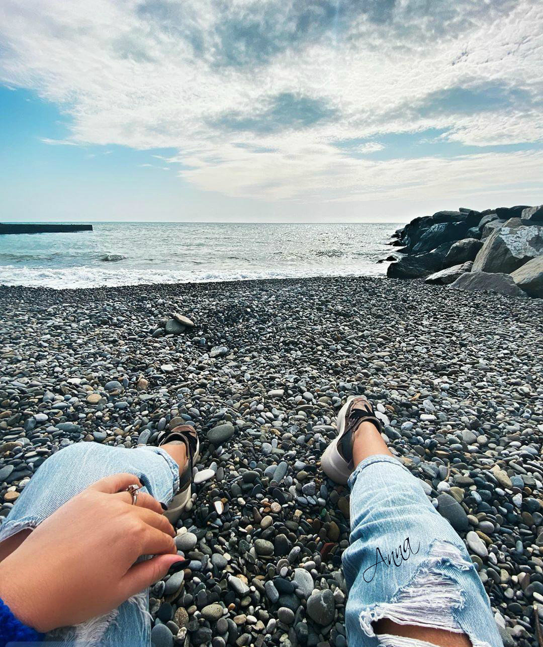 Девушка снимает джинсы на берегу моря