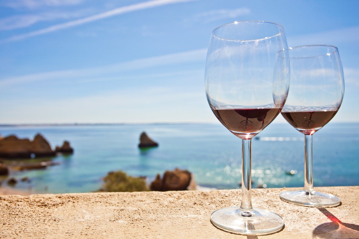 Фужер розового вина на фоне моря