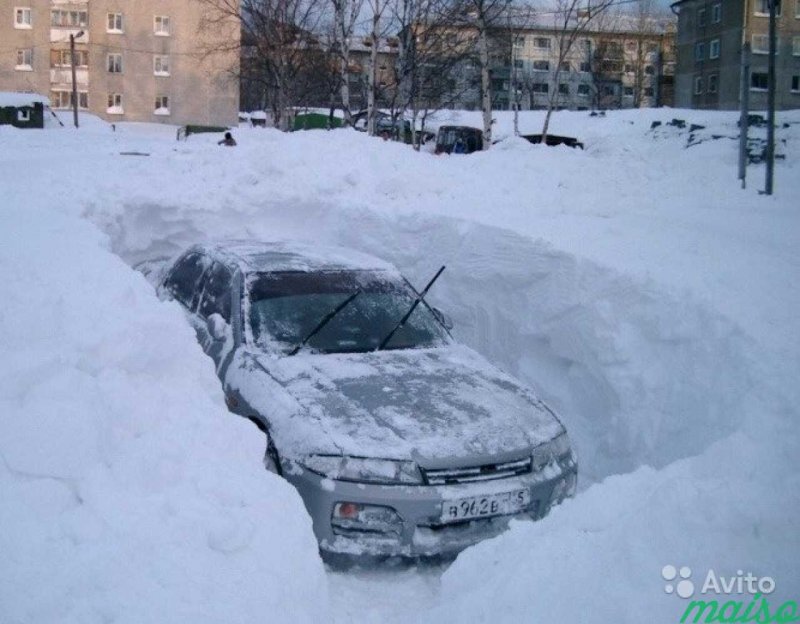 Откапывает машину от снега