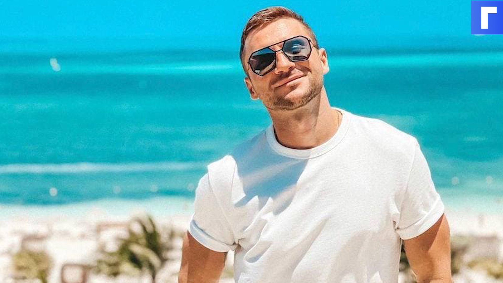 Русский певец в полосатой футболке в очках на берегу моря клип