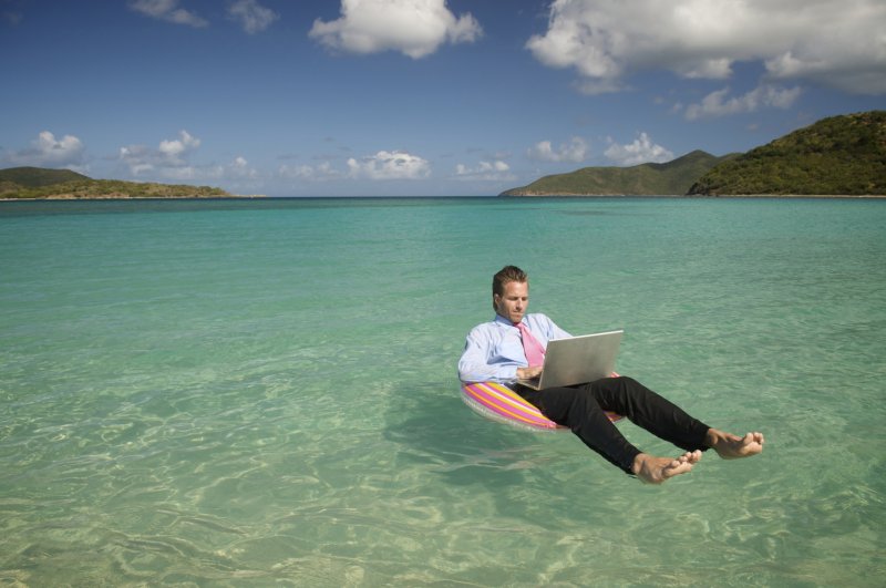 Человек с ноутбуком на море