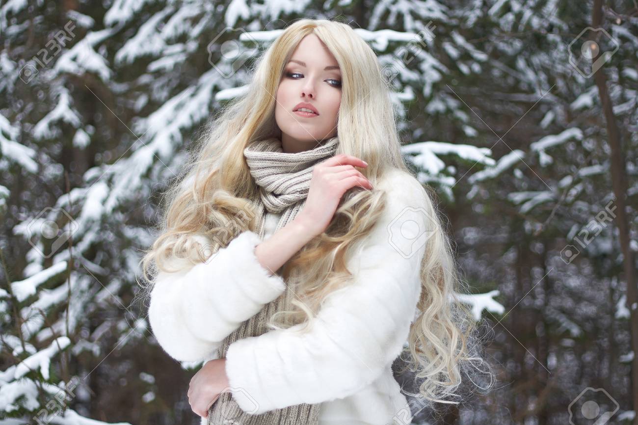 Блондинка в шубе зимой в лесу