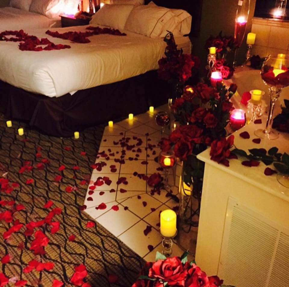 Лепестки роз на кровати и свечи