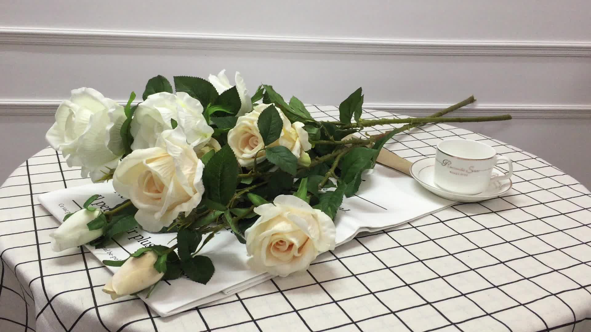 Белые розы на столе напротив окна
