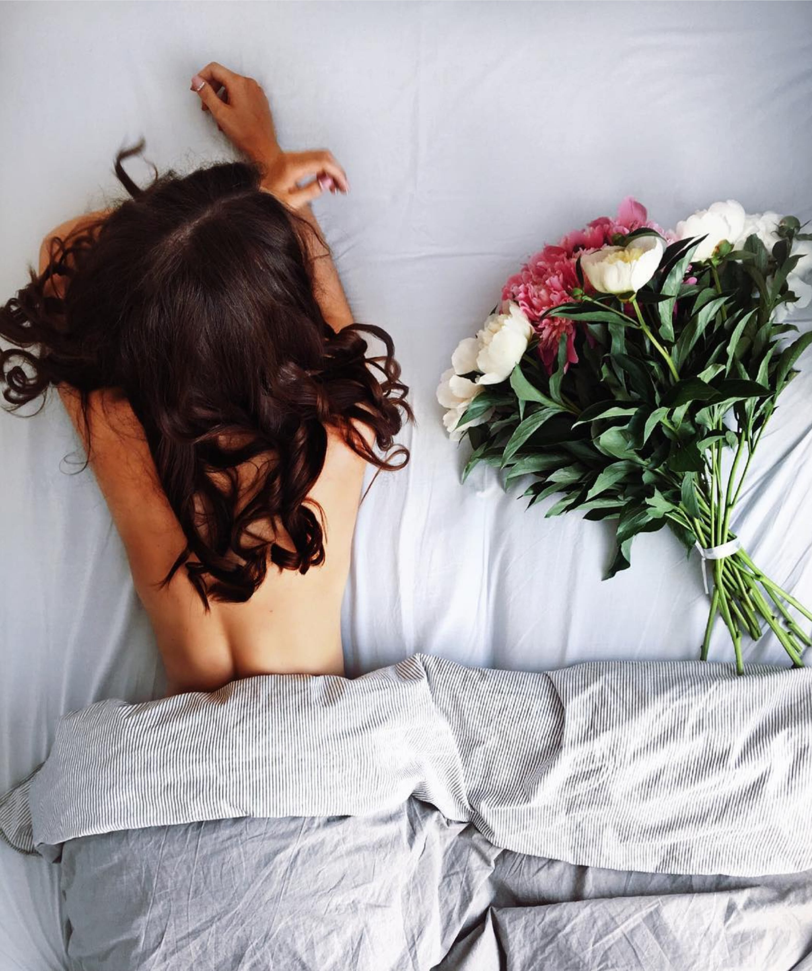 Девушка с цветами на кровати