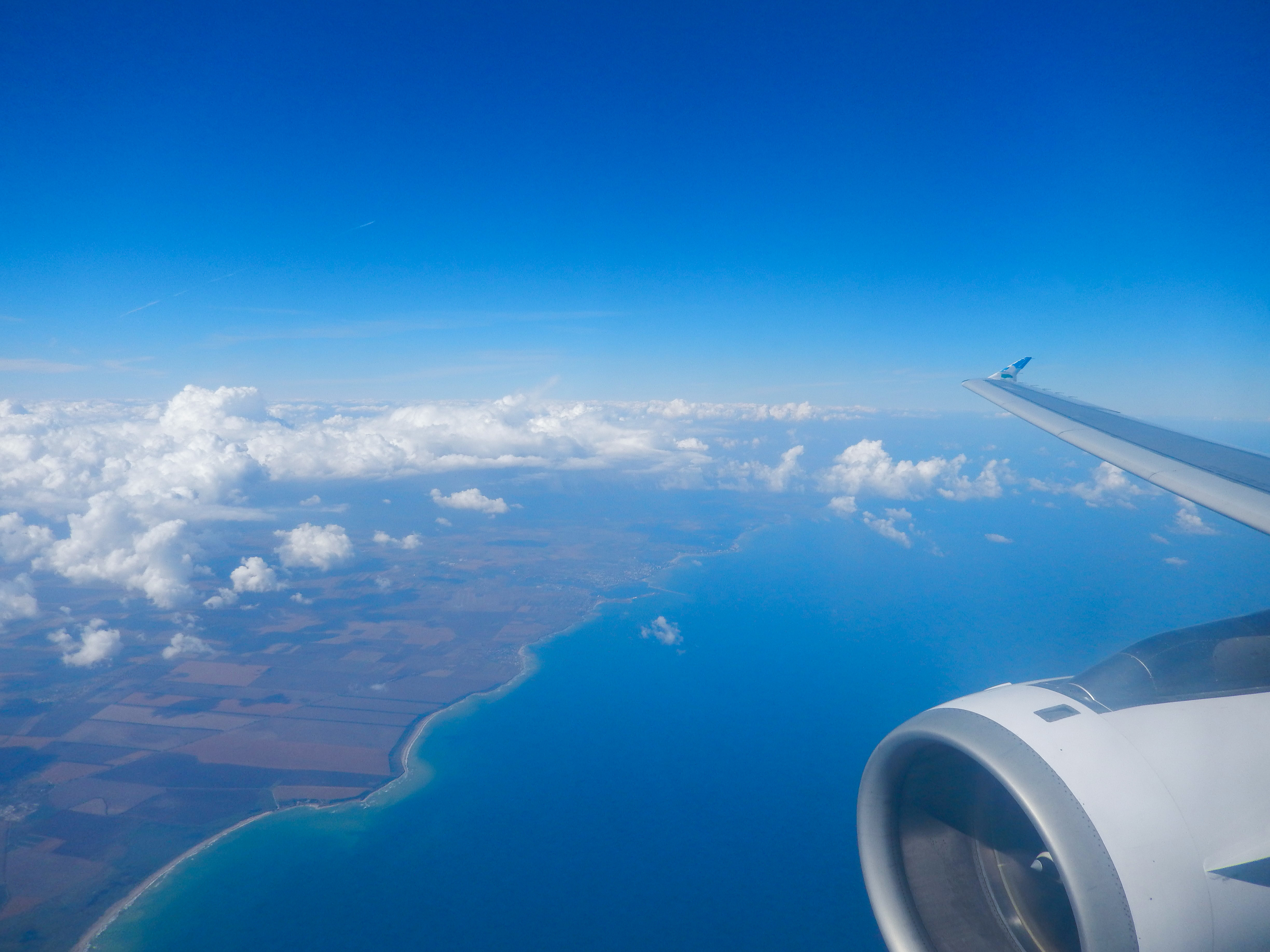 Полет через океан. Вид из самолета. Вид из иллюминатора самолета. Самолет в небе. Красивый вид из самолета.