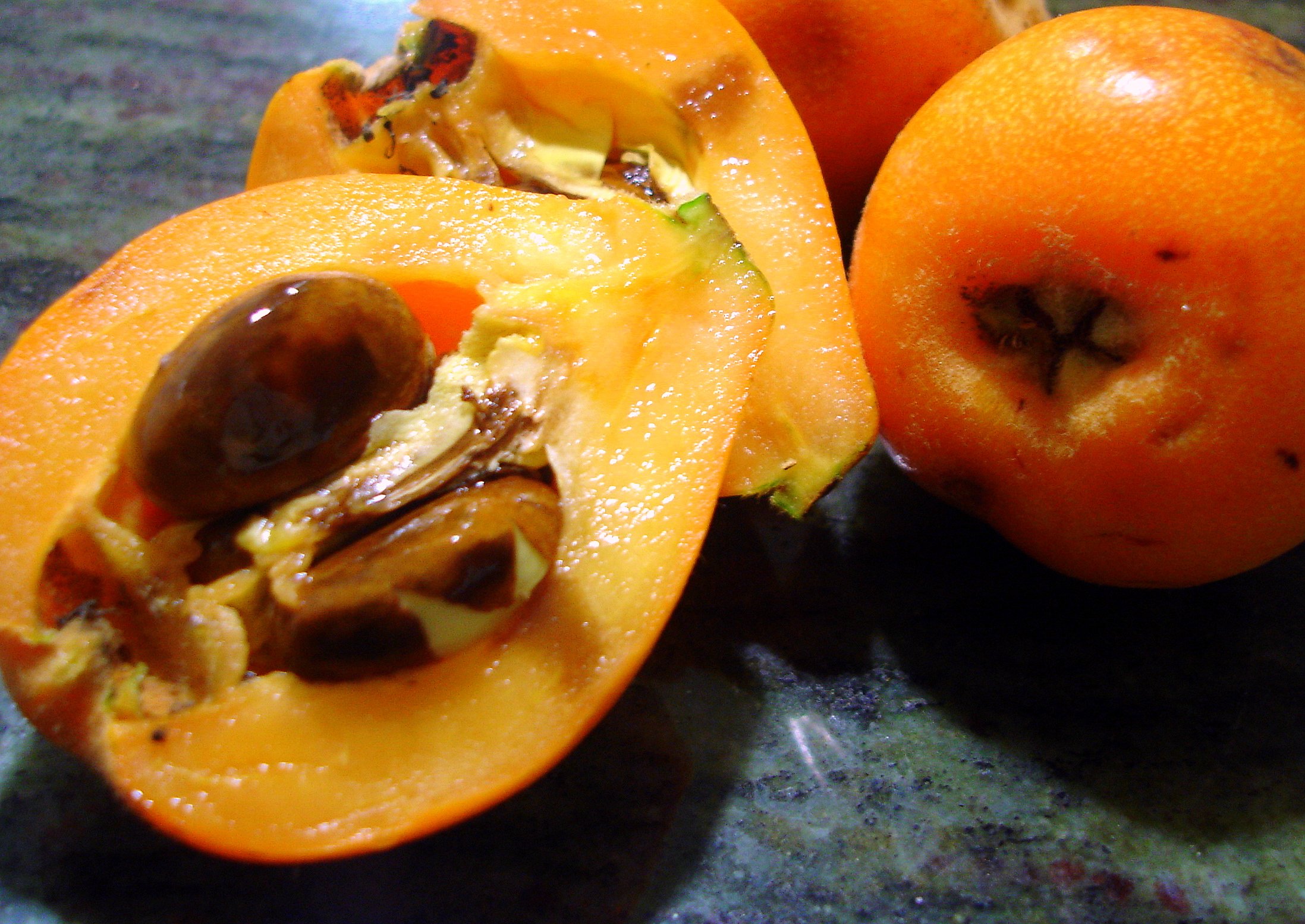 Красно желтый фрукт. Нисперо мушмула. Мушмула Тайланд. Оранжевый фрукт мушмула. Фрукт оранжевый с косточками мушмула.