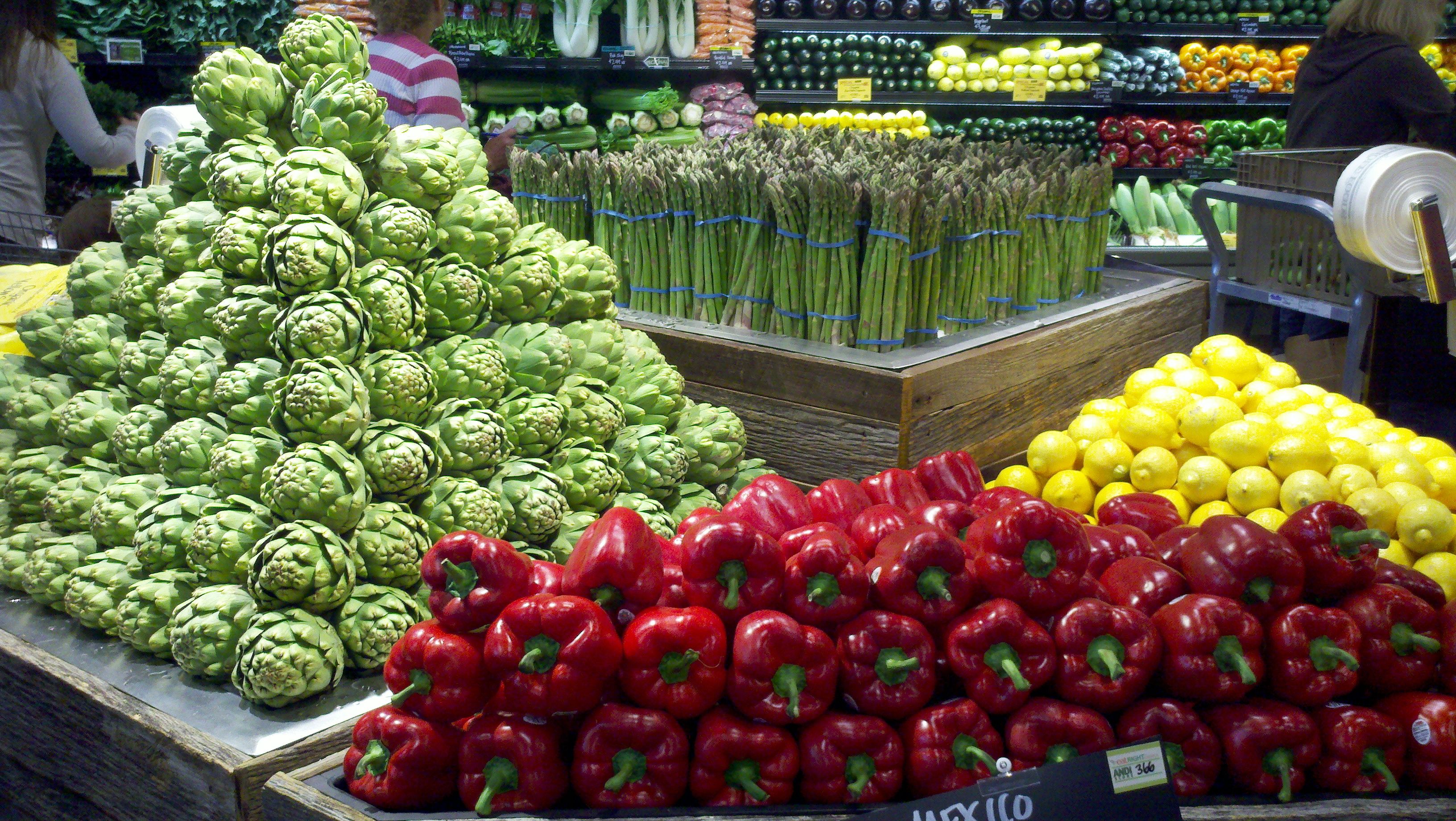 На прилавках магазинов лежат отборные овощи. Выкладка овощей и фруктов. Выкладка овощей и фруктов в магазине. Овощной прилавок. Красивая выкладка овощей и фруктов.