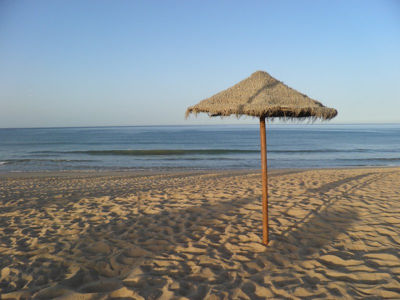 Пустынный пляж с зонтиками