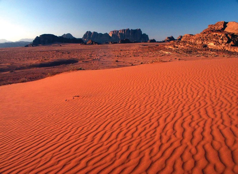 Красный песок пустыни с водоемом