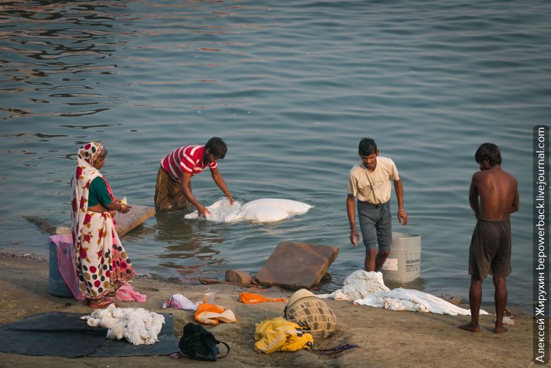 Женщина стирает белье в реке