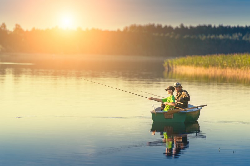 Рыбак в лодке на озере