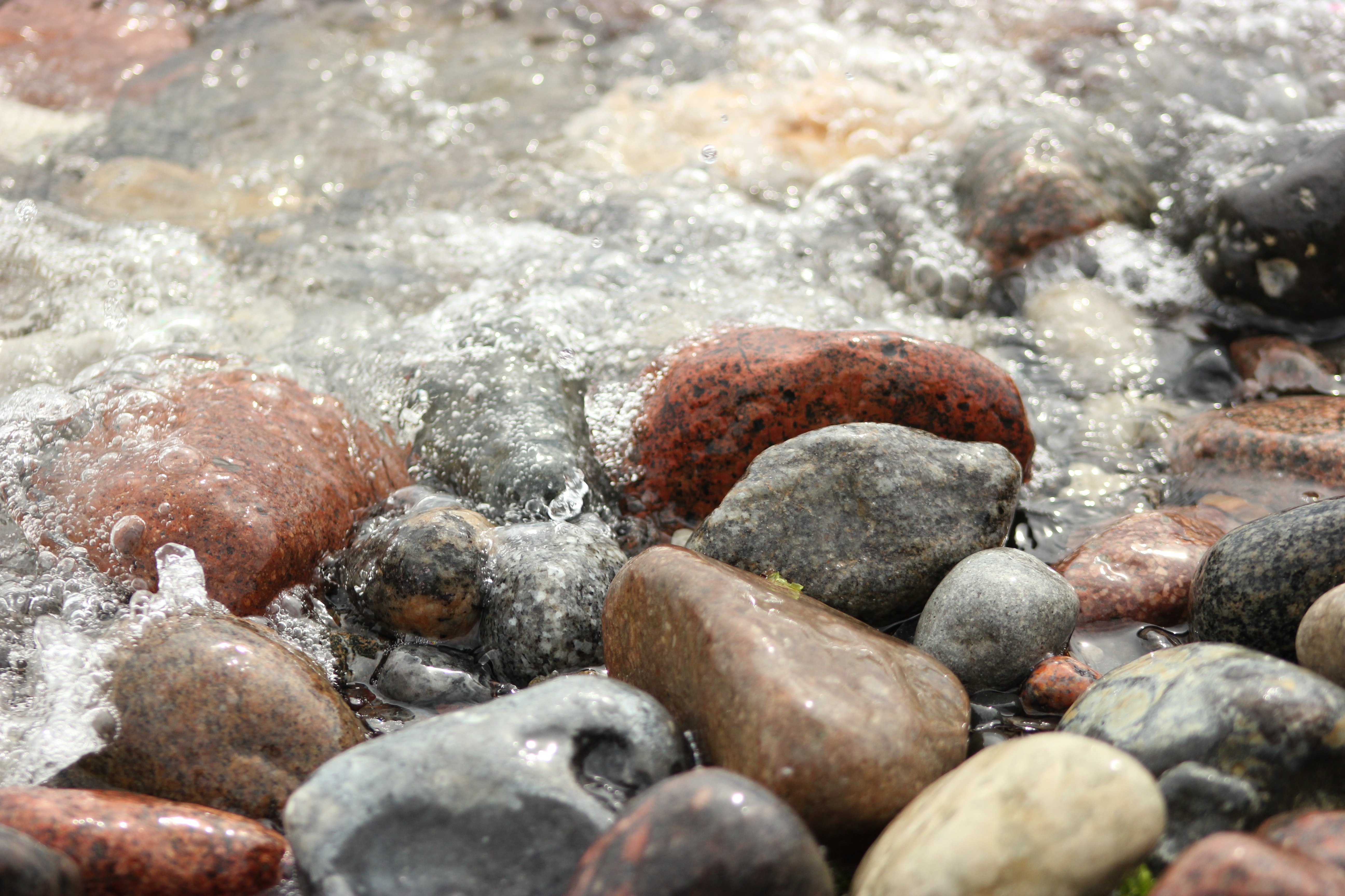 Пошла вода на камень. Камешки в воде. Мокрый камень. Валун в воде. Мокрые камни в море.