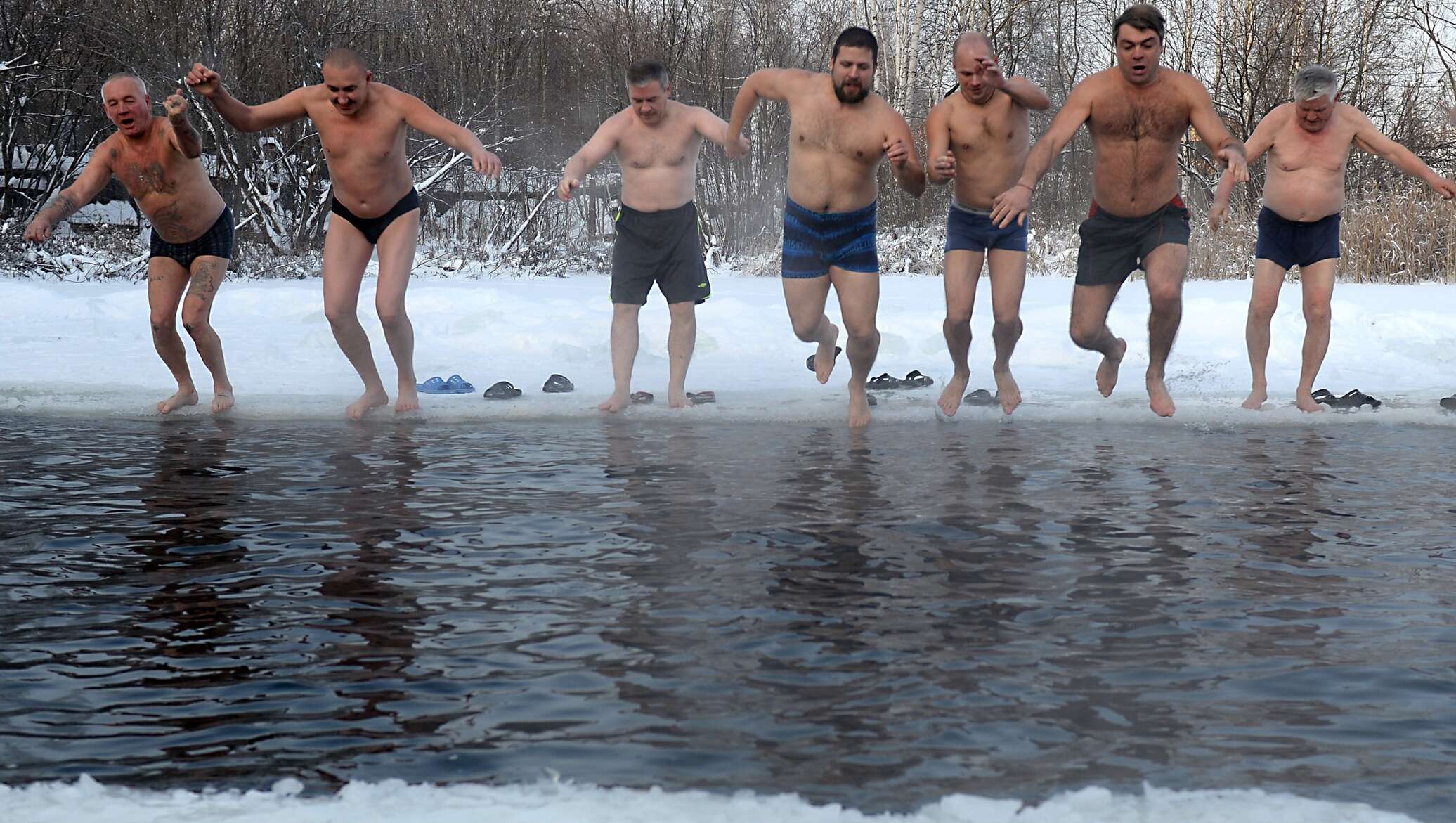 Русские купаются видео. Зимнее купание. Купание зимой в проруби. Моржи купаются.