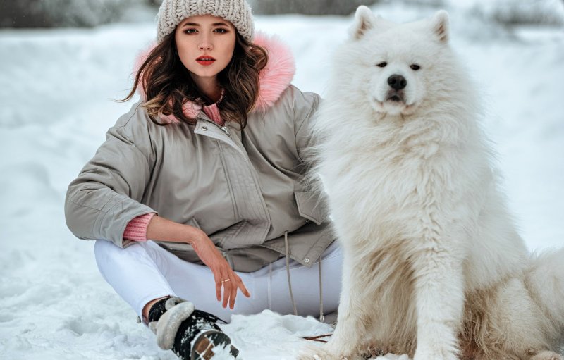Девушка с собакой в лесу зимой