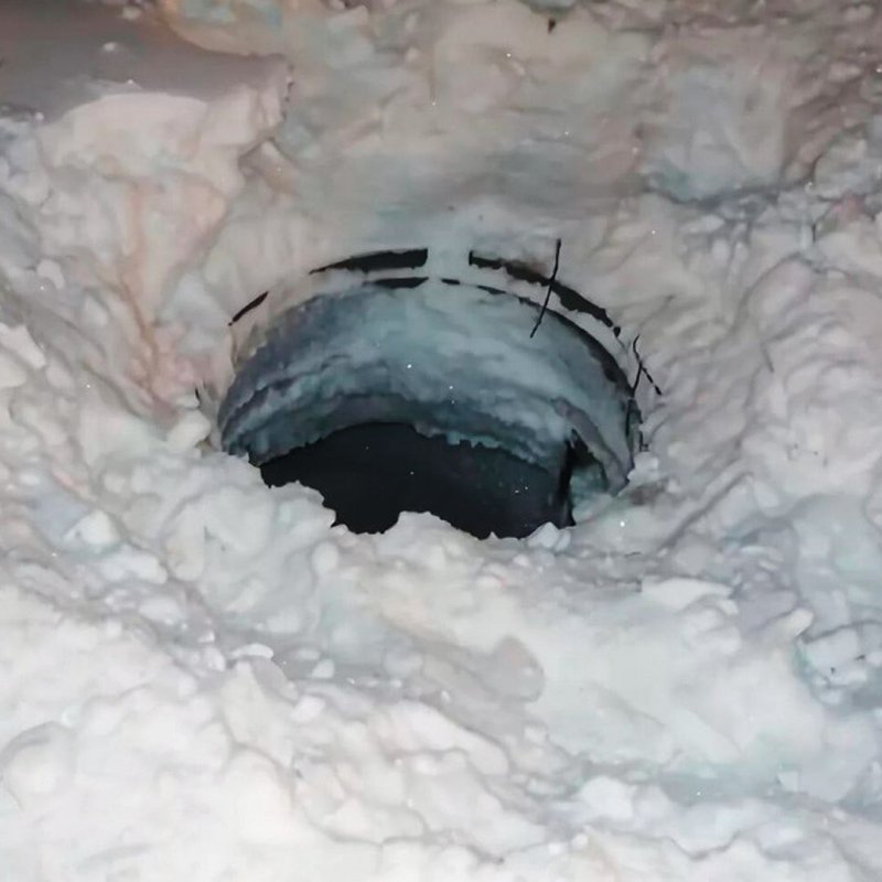 Открытый канализационный люк зимой