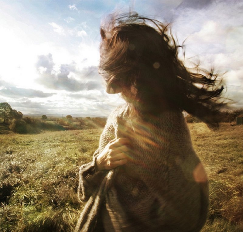 Девушка с развевающимися волосами в поле