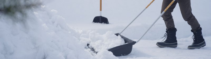 Лопата для уборки снега на фоне снега