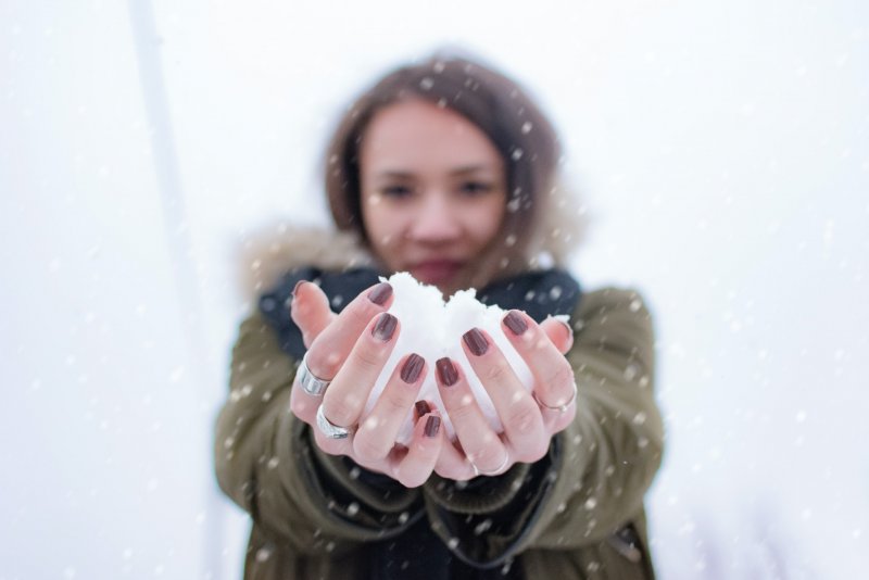 Сердце из снега в руках девушки