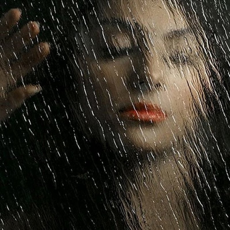 Девушка сидит под дождем