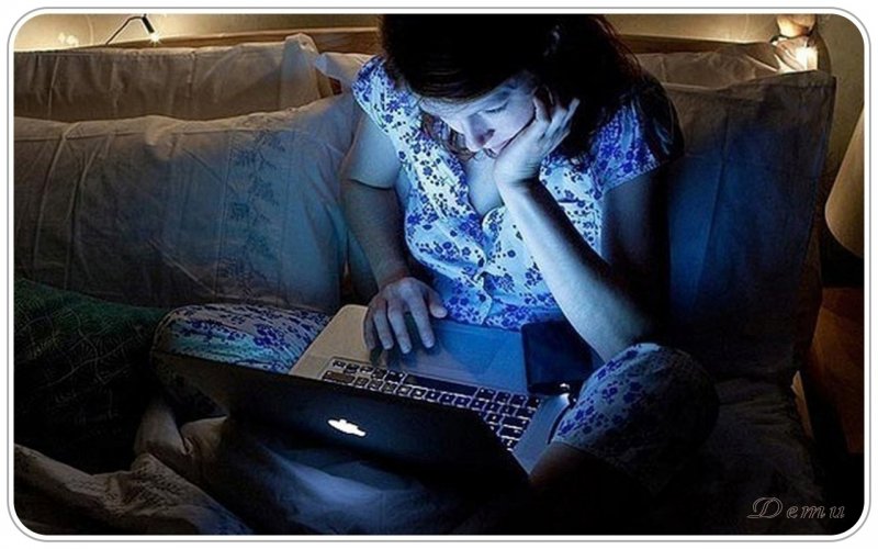 Человек сидит за компьютером ночью