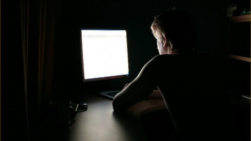 Человек за компьютером в темноте