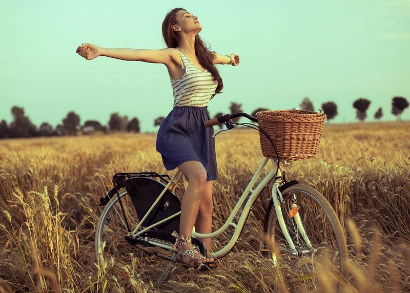 Девушка на велосипеде в поле