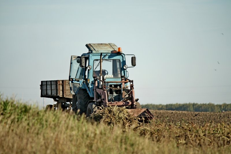 Трактор John Deere на зеленом поле